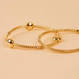 Pulsera extensible de malla en oro 18k, con diseño bicolor en oro amarillo y blanco, y detalle de esfera central pulida.