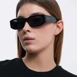 Lentes de sol negros con montura rectangular gruesa de acetato y lentes polarizadas con protección UV400. Diseño moderno con detalles biselados en el marco.