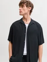 Camisa negra de manga corta con cuello cubano y cierre frontal con botones.