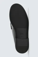 Mocasín de vestir tipo penny loafer, fabricado en piel con acabado brillante, horma redonda y suela con ligero tacón.