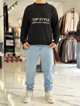 Sweater de punto color beige con cuello redondo, manga larga y diseño estampado en el pecho con las frases "TOP STYLE" y "follow your dreams" en color marrón.
