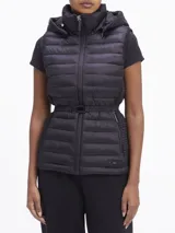 Chaleco negro acolchado con capucha, cierre frontal con cremallera, cinturón con hebilla metálica y bolsillos laterales con cremallera.