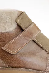 Bota corta de cuero marrón con puntera de gamuza, cuello de piel sintética negra, cierre con velcro y suela track negra.