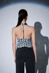 Top sin mangas con cuello halter y diseño ajustado al cuerpo, con estampado de piel de serpiente en tonos grises y negros.