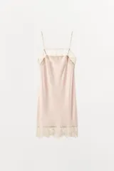 Vestido corto tipo lencero confeccionado en tejido satinado, con escote recto y tirantes finos ajustables. Presenta aplicaciones de encaje a contraste en el escote y en el ruedo.