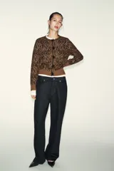 Chaqueta de punto con diseño jacquard de estampado animal en tonos marrón y negro. Presenta cuello redondo, manga larga y cierre frontal con botones decorados con abalorios.