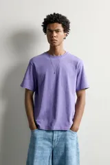 Camiseta regular fit de algodón con textura flamé, cuello redondo y manga corta, en color lila con efecto lavado y pequeña etiqueta estampada en el borde inferior.