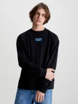 Remera de manga larga Calvin Klein Jeans, color negro, con corte oversized y cuello redondo. Presenta un logo estampado en el centro del pecho sobre una franja horizontal azul.