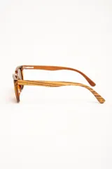 Lentes de sol polarizados con armazón transparente y patillas de madera, con cristales oscuros.