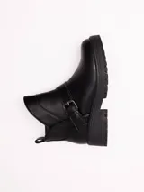 Bota corta de cuero sintético color negro, con suela track de goma y detalle de tira con hebilla metálica en el tobillo.