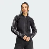 Campera de denim negro con efecto lavado, corte corto y ajustado. Cuenta con cierre frontal y las clásicas tres tiras de Adidas en las mangas.