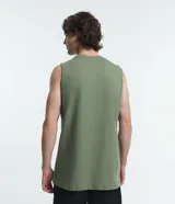 Musculosa básica para hombre de corte recto y cuello redondo, confeccionada en tejido de algodón. Presenta un diseño liso con un pequeño tag decorativo en el bajo.
