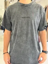 Remera de corte oversize color azul, con efecto gastado y pequeño texto bordado en el pecho.