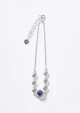 Pulsera de plata 925 con cadena veneciana, decorada con circones blancos en bisel y un circón central azul rodeado de circones más pequeños. Incluye cadena de extensión con dije en forma de corazón.