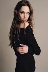 Vestido largo de color marrón oscuro, con cuello fluido tipo bote, manga larga y detalle de fruncido lateral con broche metálico en la cintura.