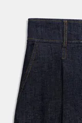 Bermuda de tiro alto en denim azul oscuro, corte ancho tipo culotte, con pinzas delanteras y pespuntes en color caramelo.