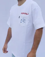 Remera blanca de algodón con cuello redondo y bolsillo en el pecho con estampado de montaña.
