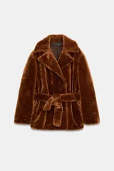 Chaqueta de textura efecto pelo en color marrón, con cuello de solapa, manga larga y cierre frontal cruzado mediante un cinturón del mismo tejido. Cuenta con bolsillos delanteros.