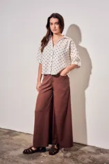 Blusa de lino y viscosa color blanco con estampado de lunares marrones, de manga corta y cuello camisero con cierre frontal de botones.