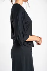 Remera negra de viscosa con elastano, escote en V y mangas tres cuartos de corte holgado.