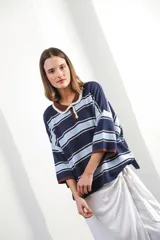 Remera de punto con rayas horizontales azul marino, celeste y blanco. Tiene cuello tipo polo con botones y mangas 3/4 amplias.