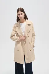 Trinchera de corte clásico, color negro, con cierre frontal de doble botonadura, solapas amplias y cinturón ajustable con hebilla en la cintura.