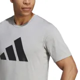 Remera de entrenamiento Adidas, color gris claro jaspeado, con cuello redondo y manga corta. Presenta el logo Badge of Sport de Adidas (tres barras inclinadas) en negro en el pecho.