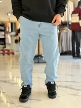 Pantalón de jean celestes de corte relaxed fit con costuras laterales decorativas y presillas.