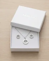 Set de joyería compuesto por collar con dije circular y caravanas a juego, ambos con diseño grabado de árbol de la vida. Realizados en acero inoxidable.