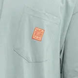 Remera celeste de corte holgado con bolsillo en el pecho y logo estampado en color naranja.