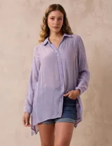 Camisa larga de rayón, con cuello clásico, cierre frontal con botones y mangas regulables con presilla. Presenta un diseño holgado con tajos laterales en el ruedo.