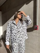 Camisa de denim con estampado de manchas de vaca, corte recto y cierre frontal con botones.