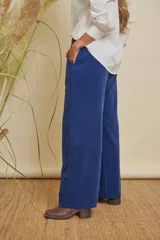 Pantalón de pana fina color azul, de pierna ancha, con elástico en la cintura y bolsillos laterales. Incluye un cinturón de cuero marrón.