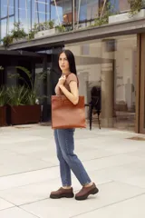 Suecos marrones de cuero con costuras decorativas y suela track negra.