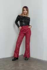 Pantalón de cuero sintético color rojo, de tiro alto y corte acampanado, con bolsillos delanteros y traseros, y botones metálicos a lo largo de la pierna.