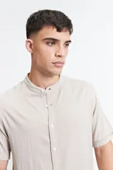 Camisa negra de manga corta con cuello mao y doblez en las mangas.