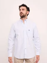 Camisa de corte regular confeccionada en tejido Oxford de algodón, con diseño de rayas verticales finas. Presenta cuello abotonado, cierre frontal con botones y un bolsillo en el pecho.