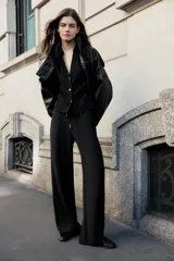 Pantalón fluido de tiro alto color verde militar, con cintura elástica ajustable con cordones y detalles de cuentas de madera. Tiene bolsillos delanteros y pierna recta.