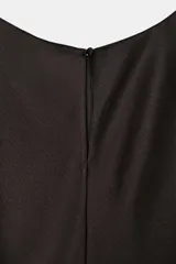 Vestido midi negro de tejido satinado con cuello redondo y manga capa. Presenta detalles de cut-out laterales adornados con encaje a tono. El bajo es asimétrico y tiene cierre en la espalda.