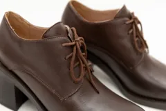 Zapato acordonado de cuero color marrón chocolate, con punta cuadrada y tacón ancho.