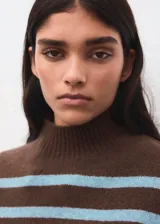 Sweater de punto con diseño de rayas horizontales en tonos marrón y celeste, cuello alto y manga larga. Presenta un corte oversize y acabado suave.