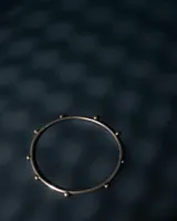 Brazalete esclava rígido de plata 925, adornado con pequeñas esferas distribuidas a lo largo de su circunferencia.