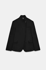 Blazer de lana con cuello subido, manga larga con botones en puños, bolsillos con solapa y bolsillo de vivo en el pecho. Cierre frontal con un botón.