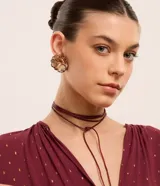 Conjunto de collar de cordón y caravanas con forma de flor con pétalos en capas y detalle en el borde, con baño de oro ligero.