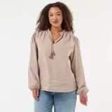Blusa de corte fluido con estampado de cuadros vichy en tonos beige y blanco. Presenta cuello mao con cordón ajustable terminado en borlas y mangas largas abullonadas con puños elásticos.
