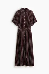 Vestido midi bordó con estampado de lunares blancos, cuello camisero, botonadura frontal y mangas cortas raglán. Cuenta con elástico en la parte posterior de la cintura y cinturón extraíble para atar.