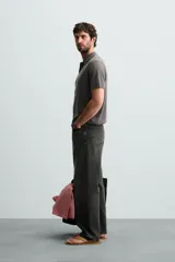 Polo de punto canalé color rosado, de corte regular fit, con cuello solapa y cierre frontal de botonadura. Manga corta y acabados en rib.