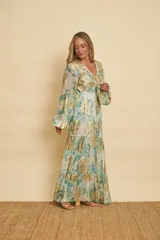 Vestido largo con estampado floral en tonos verde agua y detalles metalizados dorados, con escote en V, mangas largas abullonadas y falda de diseño escalonado.