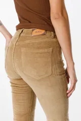 Pantalón de jean tipo pana color negro, de corte acampanado y tiro medio, con cierre frontal y bolsillos laterales.