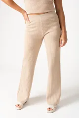 Pantalón palazzo beige de viscosa, poliéster y elastano, con cintura elástica y corte amplio.